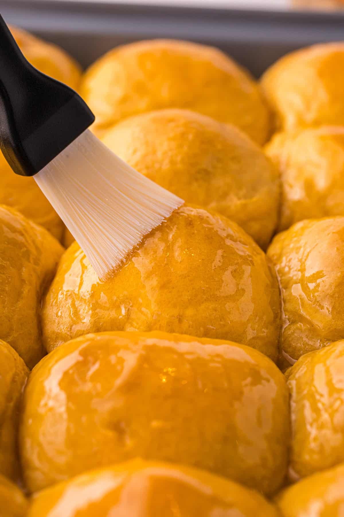 These soft, fluffy Sweet Potato Rolls are brushed with warm honey butter right out of the oven. Easy to make with a few basic ingredients! Brushing honey glaze on sweet potato rolls