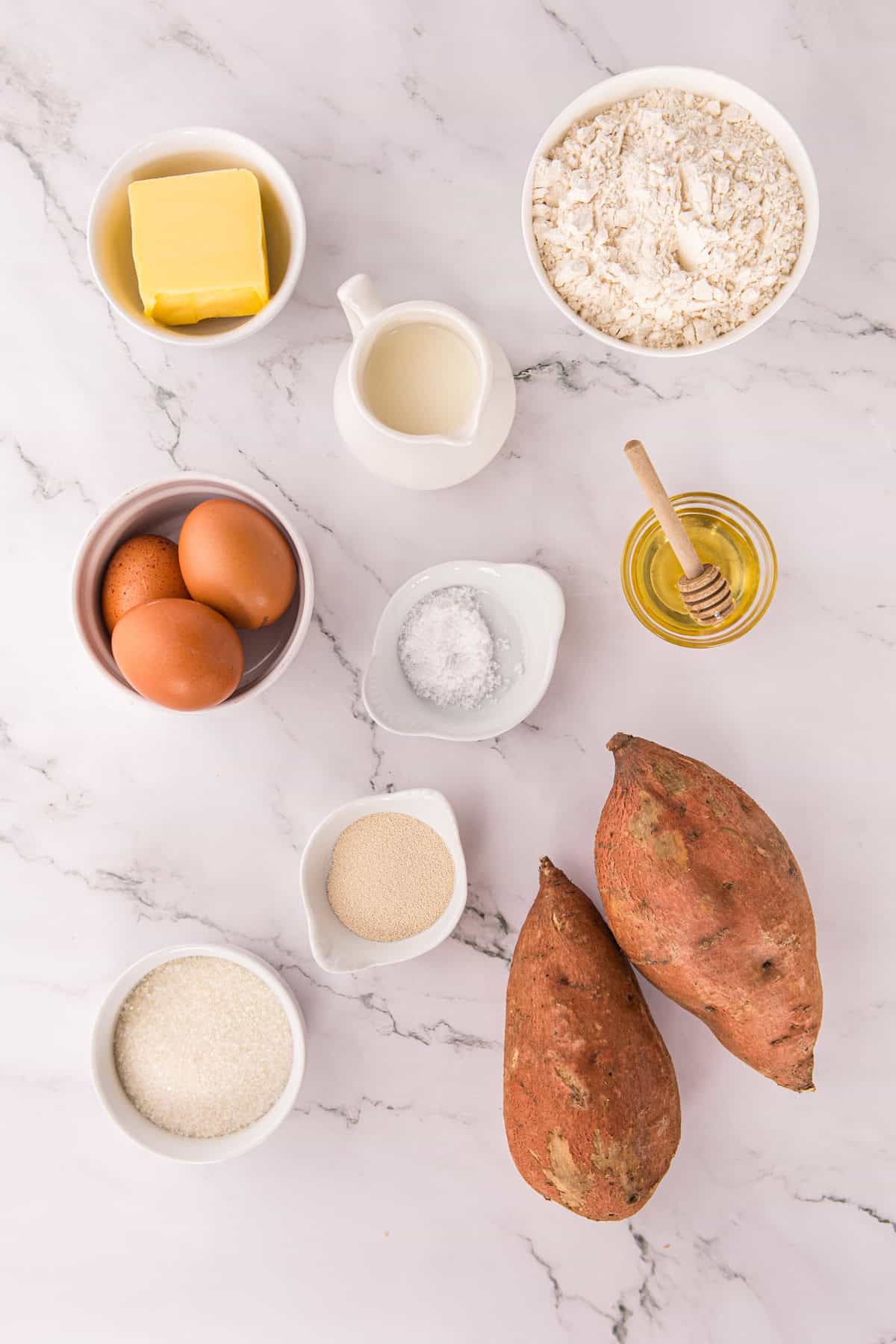 These soft, fluffy Sweet Potato Rolls are brushed with warm honey butter right out of the oven. Easy to make with a few basic ingredients! Overhead view of ingredients needed to make sweet potato rolls