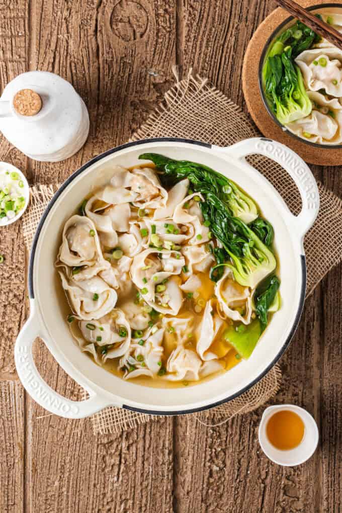 This easy Wonton Soup features tender homemade wontons filled with juicy pork and shrimp in a light, aromatic chicken broth. Overhead view of a pot of wonton soup
