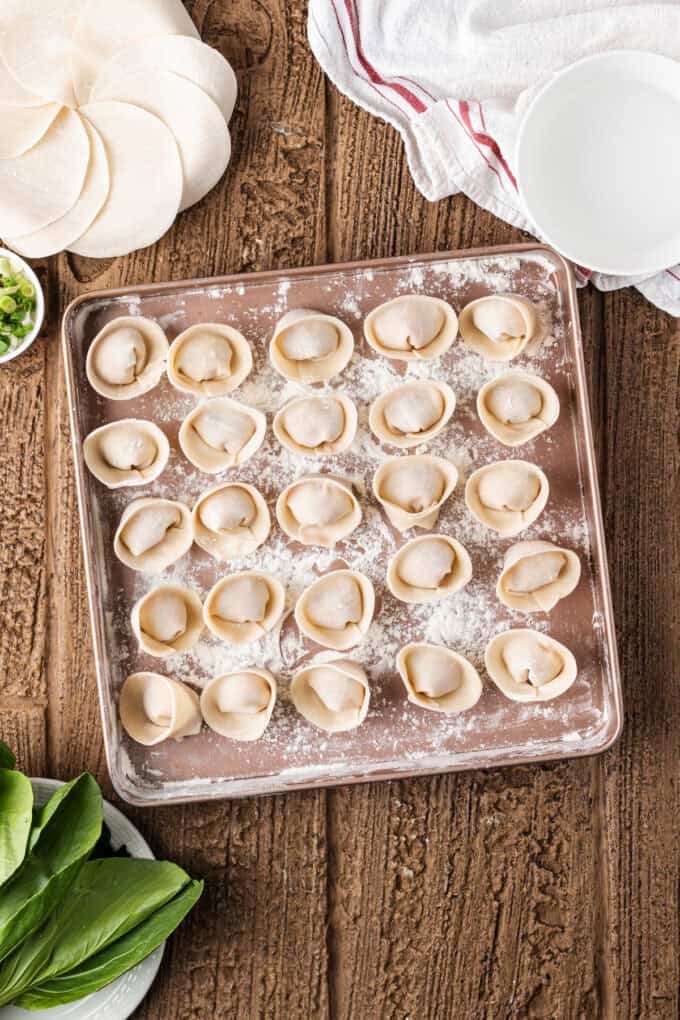 This easy Wonton Soup features tender homemade wontons filled with juicy pork and shrimp in a light, aromatic chicken broth. Wontons on a baking sheet