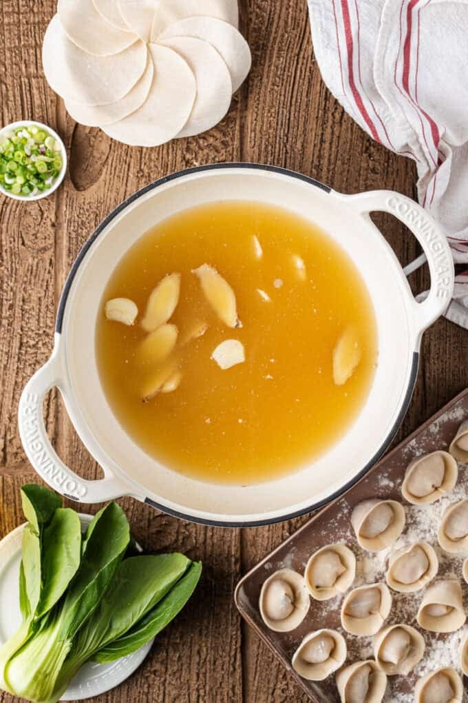 This easy Wonton Soup features tender homemade wontons filled with juicy pork and shrimp in a light, aromatic chicken broth. Ginger and garlic in a pot of broth