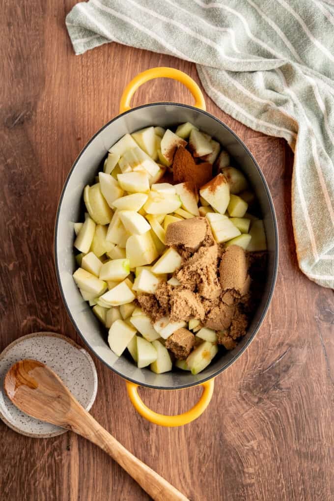 Tender spiced apple filling is topped with a snickerdoodle batter to make this irresistible Apple Cobbler recipe. Apple pieces in a pan with spices
