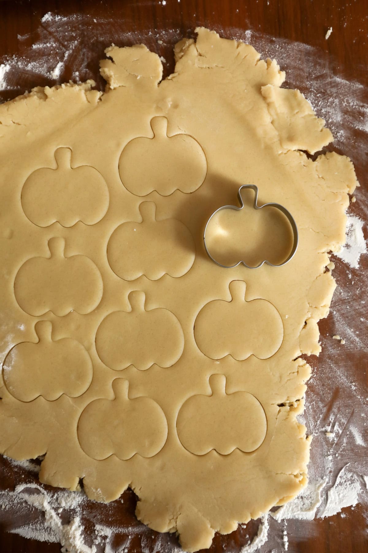 These Halloween Sugar Cookies are soft, buttery cut-out cookies decorated with colorful icing for a fun and festive Halloween treat. cutting out pumpkin shapes from the sugar cookie dough using a cookie cutter.